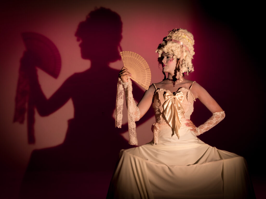 Modelo caracterizada no estilo Rococó, com uma sombra projetada que desenha sua silhueta.